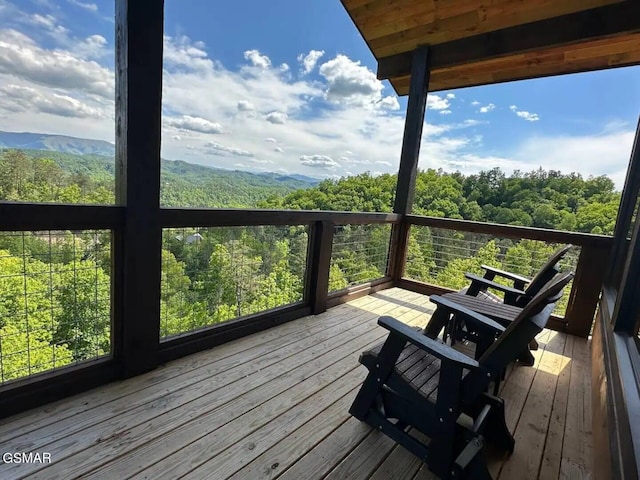 wooden terrace featuring a forest view