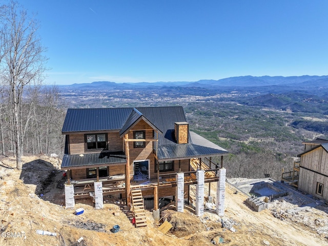 view of front of property featuring a chimney, a mountain view, and metal roof