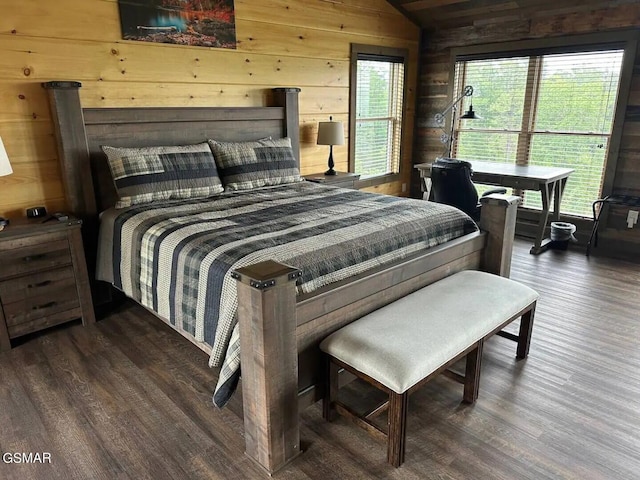 bedroom with vaulted ceiling, wood walls, and wood finished floors