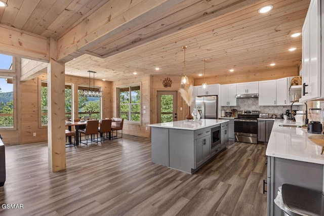 kitchen featuring dark wood-style floors, wood ceiling, gray cabinets, stainless steel appliances, and light countertops