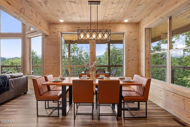 dining room with wood ceiling, wooden walls, and wood finished floors