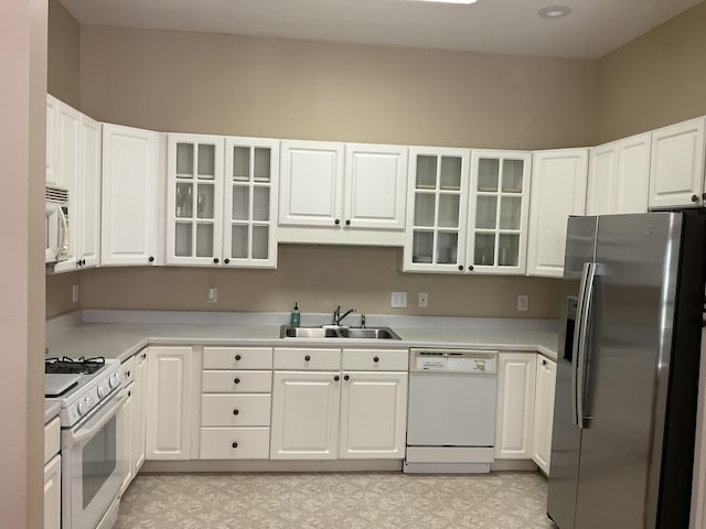 kitchen featuring sink, white cabinets, and white appliances