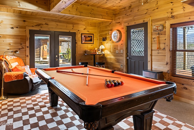 game room featuring carpet, beamed ceiling, wood walls, wood ceiling, and french doors