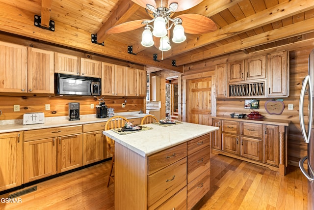 kitchen with beamed ceiling, wooden ceiling, light countertops, and light wood-type flooring