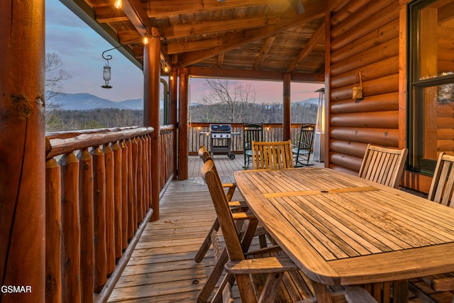 deck with outdoor dining space and a mountain view