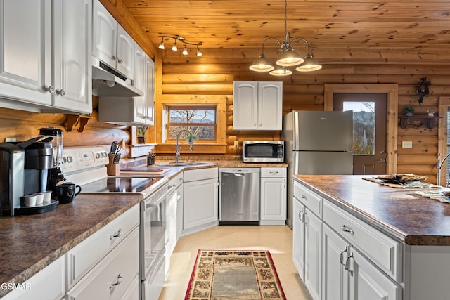 kitchen with a sink, dark countertops, appliances with stainless steel finishes, white cabinets, and wood ceiling