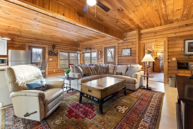 living room featuring beam ceiling, rustic walls, wood ceiling, and a ceiling fan