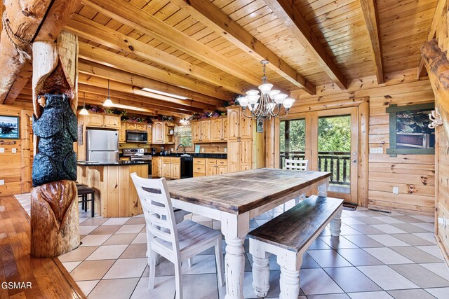 dining area with wood walls, beamed ceiling, wooden ceiling, and light tile patterned floors