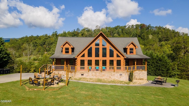 back of house with a lawn and a patio