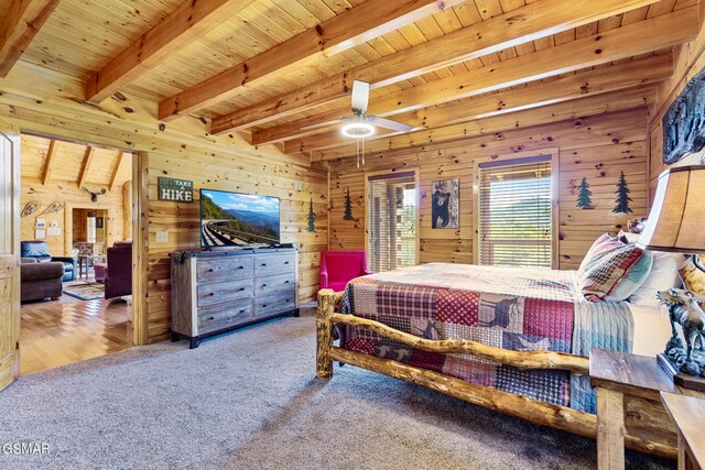 carpeted bedroom with beamed ceiling, wood ceiling, and wooden walls