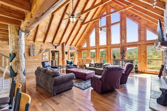 living room with wood walls, wooden ceiling, high vaulted ceiling, hardwood / wood-style flooring, and beamed ceiling