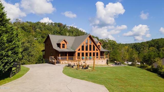 rear view of property featuring a yard and a wooden deck