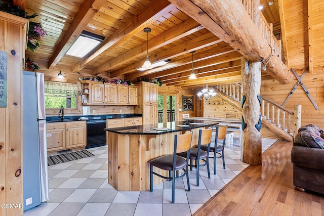 kitchen featuring stainless steel refrigerator, a kitchen island, black dishwasher, beamed ceiling, and light tile patterned floors