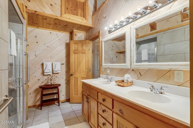 bathroom featuring tile patterned floors, wooden walls, a stall shower, and a sink