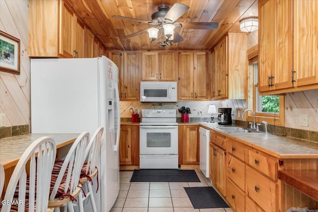 kitchen featuring tasteful backsplash, tile counters, light tile patterned floors, white appliances, and a sink