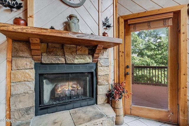 room details featuring a stone fireplace and wood walls