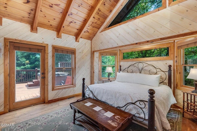 bedroom with lofted ceiling with beams, multiple windows, access to exterior, and wood finished floors