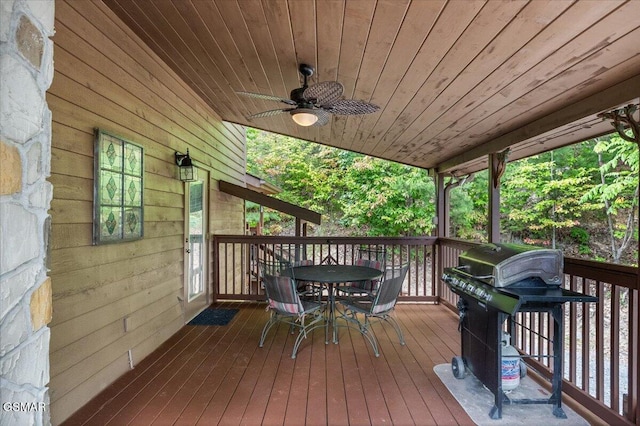 wooden deck featuring area for grilling, outdoor dining area, and a ceiling fan