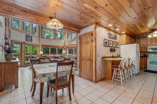 dining space with light tile patterned flooring, wood walls, and wooden ceiling