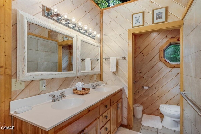 full bathroom with double vanity, toilet, tile patterned floors, and a sink