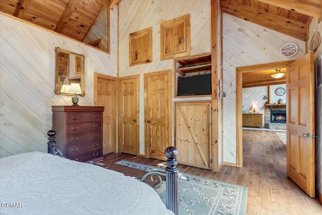 bedroom with hardwood / wood-style floors, high vaulted ceiling, wood ceiling, wood walls, and beamed ceiling