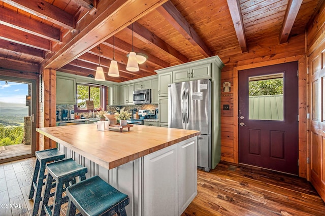 kitchen featuring a center island, stainless steel appliances, beamed ceiling, butcher block countertops, and hardwood / wood-style floors