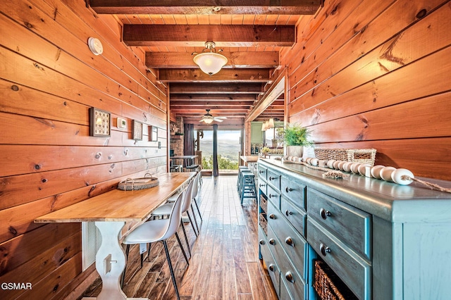 kitchen with beamed ceiling, ceiling fan, wood ceiling, and hanging light fixtures