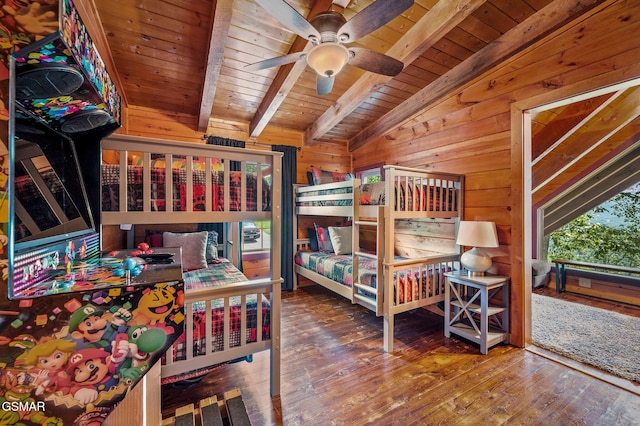 bedroom with ceiling fan, wooden walls, lofted ceiling with beams, hardwood / wood-style flooring, and wooden ceiling