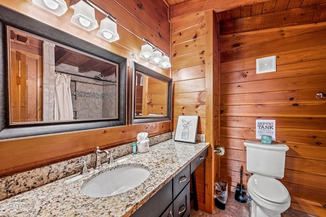 bathroom with a shower with shower curtain, vanity, toilet, and wooden walls