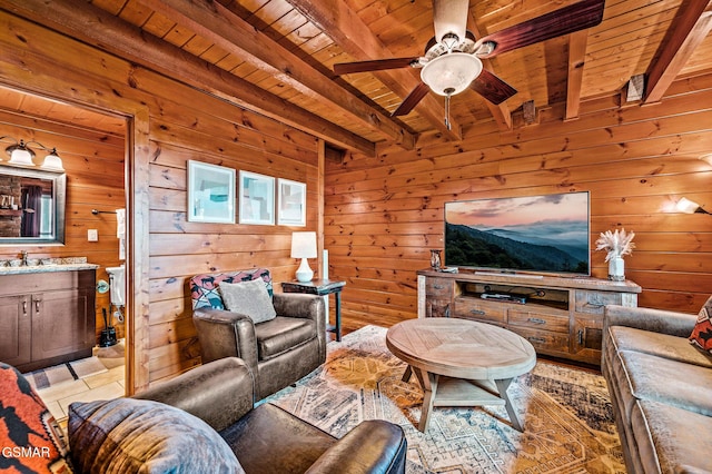 living room with wood ceiling, ceiling fan, sink, beam ceiling, and wood walls