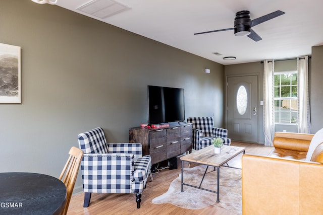 living room with a ceiling fan, wood finished floors, and visible vents