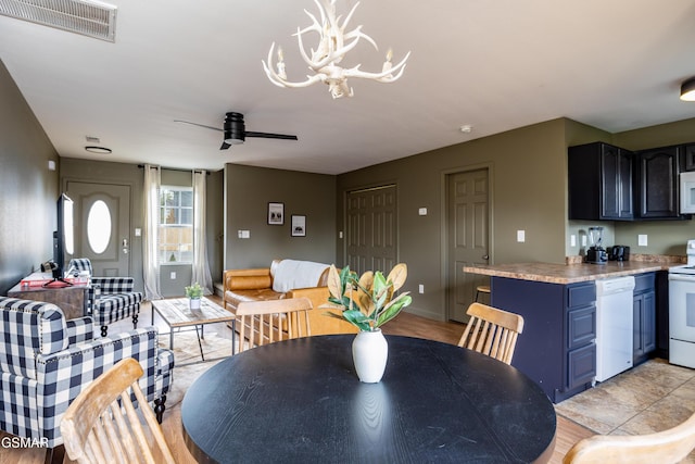 dining room with visible vents and ceiling fan with notable chandelier