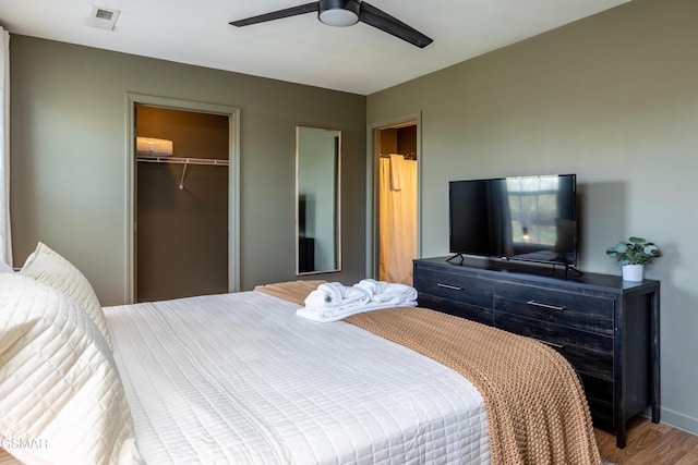 bedroom with visible vents, a ceiling fan, wood finished floors, a closet, and baseboards