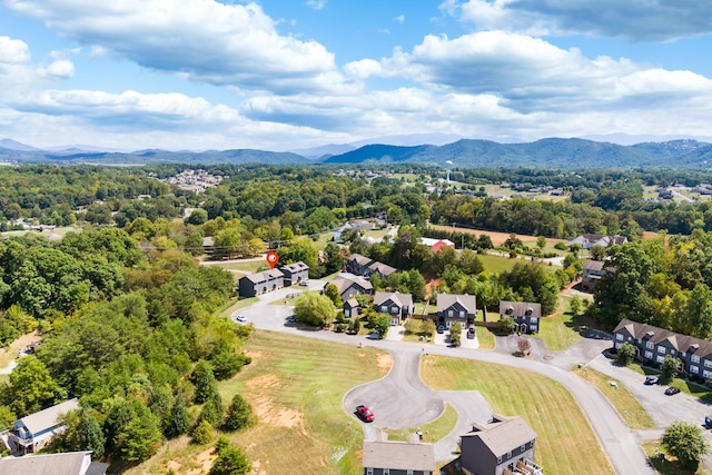 drone / aerial view with a wooded view and a mountain view