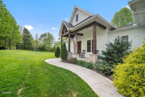 view of side of property featuring a lawn and a porch
