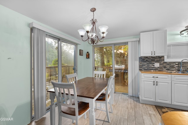 dining room with a notable chandelier, light hardwood / wood-style floors, and sink