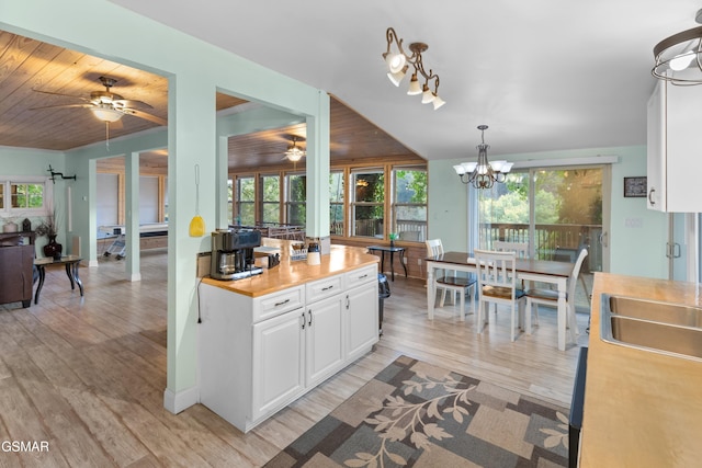 kitchen with pendant lighting, a notable chandelier, light hardwood / wood-style floors, and white cabinetry