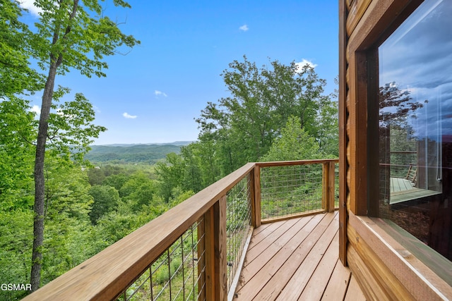 wooden terrace with a wooded view