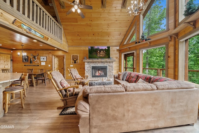 living area with wooden walls, high vaulted ceiling, and a healthy amount of sunlight