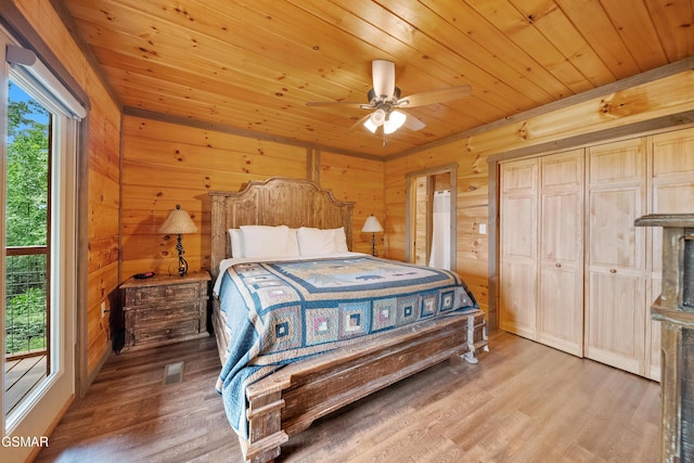 bedroom featuring wooden walls, wood ceiling, and wood finished floors
