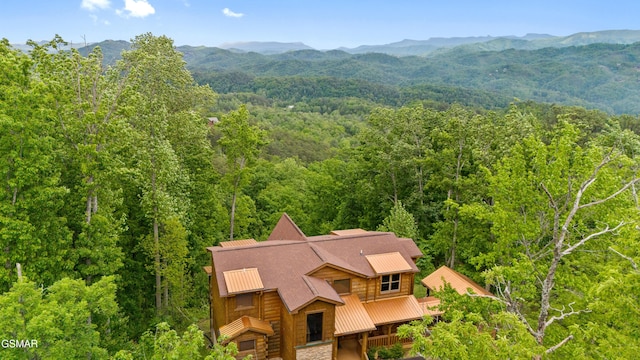 drone / aerial view featuring a wooded view and a mountain view