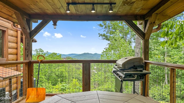 wooden terrace with a grill and a mountain view