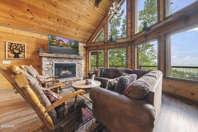 living area with plenty of natural light, visible vents, wood finished floors, and high vaulted ceiling