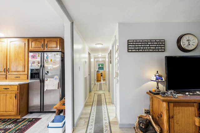 kitchen with light wood-type flooring and stainless steel fridge with ice dispenser