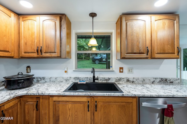 kitchen with dishwasher, sink, pendant lighting, and light stone counters