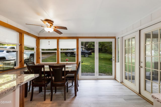 sunroom / solarium with ceiling fan, a healthy amount of sunlight, and french doors