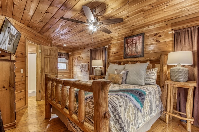 bedroom with ceiling fan, wood walls, light wood-type flooring, and wooden ceiling