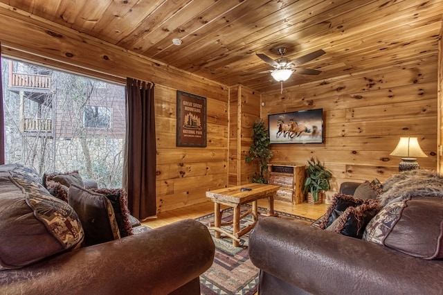 living room featuring wood-type flooring, ceiling fan, wooden walls, and wood ceiling