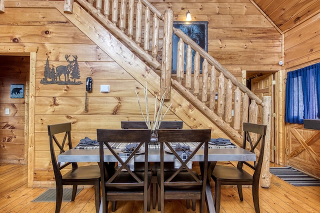 dining area featuring wood-type flooring, vaulted ceiling, wood ceiling, and wood walls