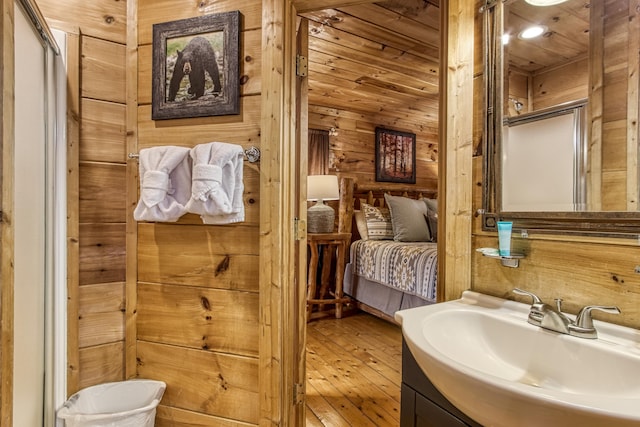 bathroom featuring walk in shower, wood walls, and hardwood / wood-style flooring